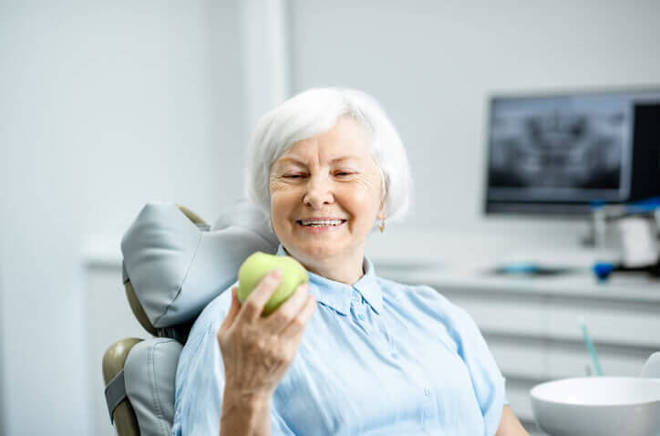 dental implants woman holding apple (1)